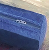 A zipper displayed on the corner of a box cushion showing that the cushion can be opened